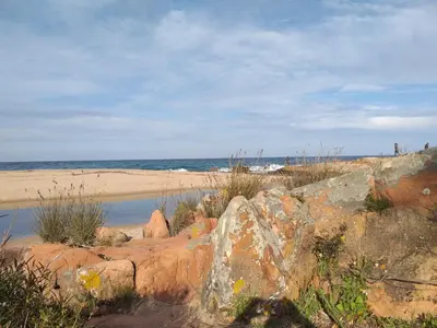 a beach with rocks and the ocean in the background at Thalassa in Sainte-Lucie de Porto-Vecchio