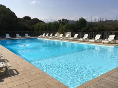 a large swimming pool with chairs and a group at Thalassa in Sainte-Lucie de Porto-Vecchio