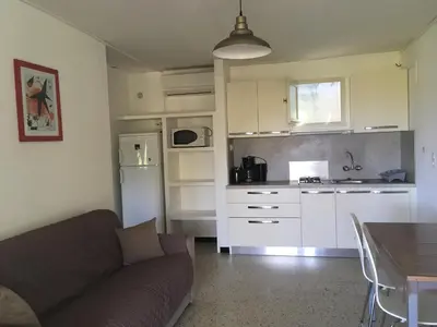 a living room with a couch and a kitchen at Thalassa in Sainte-Lucie de Porto-Vecchio