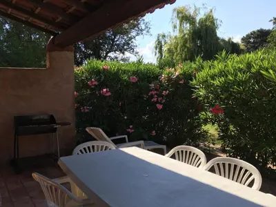 a table and chairs on a patio with flowers at Lavu Santu in Sainte-Lucie de Porto-Vecchio