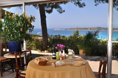 a dining table with a view of the ocean at Domaine de Saint Pierre in Cargèse