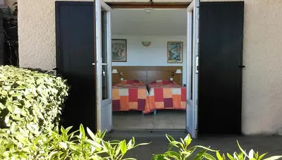 a door open to a bedroom with a bed at Domaine de Saint Pierre in Cargèse