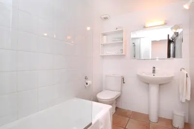 a white bathroom with a toilet and a sink at Domaine de Saint Pierre in Cargèse