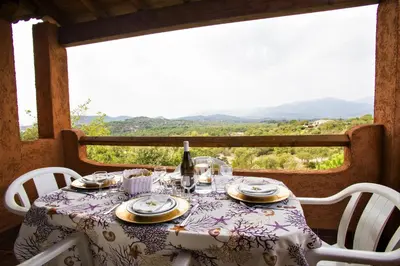 a table with a bottle of wine sitting on top at Complesso Residenziale Marina di Pinarello in Pinarellu