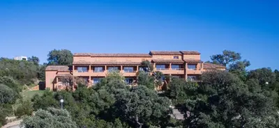 a large building on top of a hill with trees at Complesso Residenziale Marina di Pinarello in Pinarellu