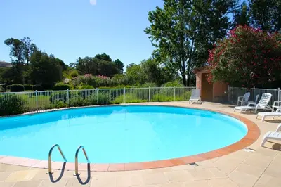 a large swimming pool with chairs around it at Complesso Residenziale Marina di Pinarello in Pinarellu