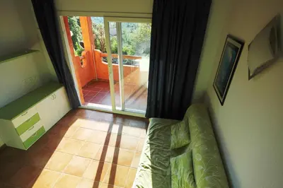 a living room with a couch and a sliding glass door at Complesso Residenziale Marina di Pinarello in Pinarellu