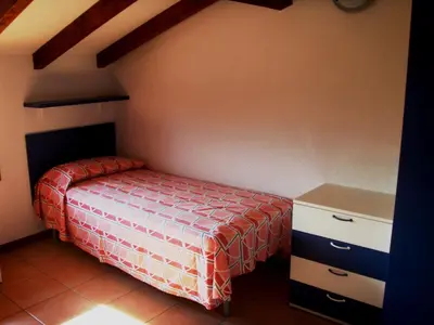 a small bedroom with a bed and a dresser at Complesso Residenziale Marina di Pinarello in Pinarellu