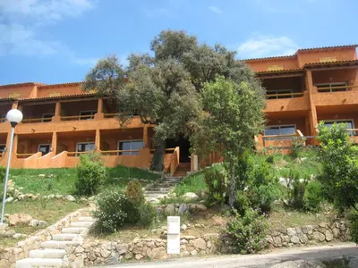 a building with stairs and trees in front of it at Complesso Residenziale Marina di Pinarello in Pinarellu