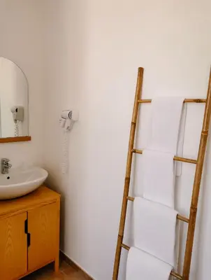 a bathroom with a towel ladder next to a sink at Maison San Giovanni in Corte