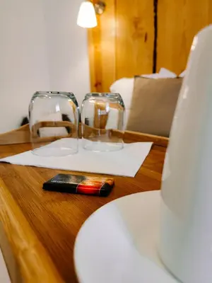 a table with two glasses and a cell phone on it at Maison San Giovanni in Corte