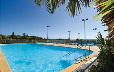 a large swimming pool with blue water and palm trees at Nice Home In Prunete With Wifi in Prunete