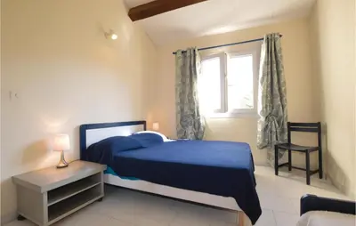 a bedroom with a blue bed and a window at Nice Home In Prunete With Wifi in Prunete