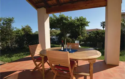 a wooden table and chairs on a patio at Nice Home In Prunete With Wifi in Prunete