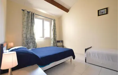 a bedroom with a blue bed and a window at Nice Home In Prunete With Wifi in Prunete