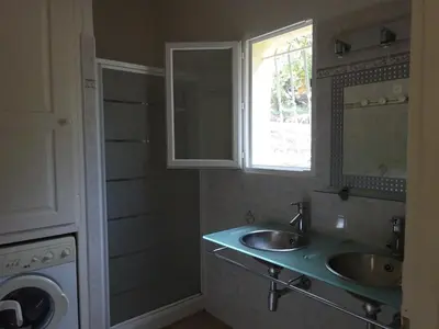 a bathroom with a sink and a washing machine at Camping Mozziconaccio in Sainte-Lucie de Porto-Vecchio