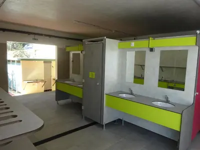 a public bathroom with two sinks and two mirrors at Camping Mozziconaccio in Sainte-Lucie de Porto-Vecchio