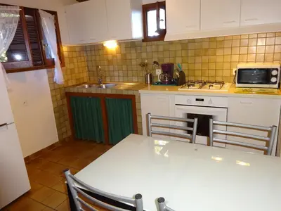 a kitchen with a white table and a stove top oven at Camping Mozziconaccio in Sainte-Lucie de Porto-Vecchio
