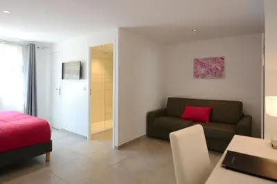 a living room with a couch and a bedroom at Hôtel A Madonetta in Bonifacio