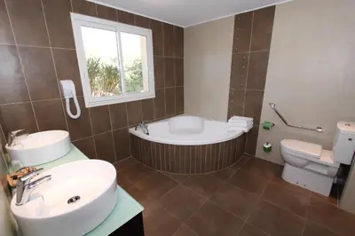 a bathroom with a tub and a sink and a toilet at Hôtel A Madonetta in Bonifacio