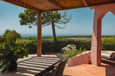 a patio with a table and chairs and a view of the ocean at Résidence Terra Marina in Bonifacio