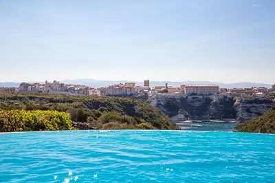 a pool of water with a city in the background at Résidence Terra Marina in Bonifacio