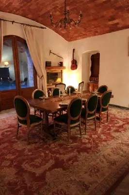 a dining room with a wooden table and chairs at U Palazzu - Demeure de charme au centre de la Corse in Corte