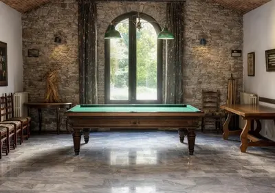 a pool table in a room with a large window at U Palazzu - Demeure de charme au centre de la Corse in Corte