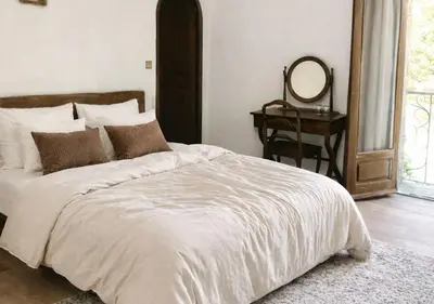 a bedroom with a bed with a mirror and a table at U Palazzu - Demeure de charme au centre de la Corse in Corte