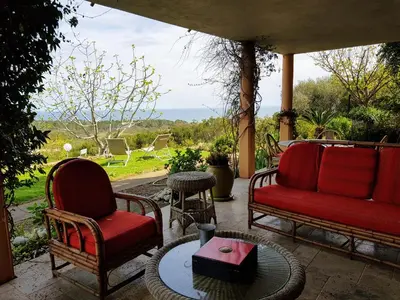 a patio with two chairs and a table with a view at Gîte L'Appart de Case Vanille in Sari Solenzara