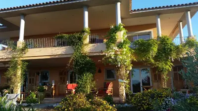 a house with ivy on the side of it at Gîte L'Appart de Case Vanille in Sari Solenzara