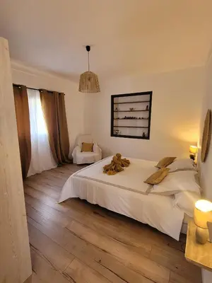 a bedroom with a large white bed and a window at Gîte Tomasini in Monacia-dʼAullène