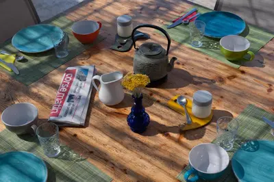 a wooden table with a tea pot and flowers on it at Maison Tavolara in Porto-Vecchio