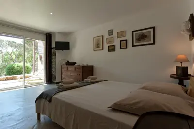 a bedroom with a large bed and a window at Maison Tavolara in Porto-Vecchio