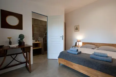 a bedroom with a bed and a table and a mirror at Maison Tavolara in Porto-Vecchio