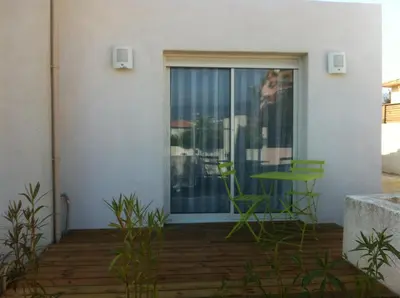 a patio with a green table and a window at T2 Campo Meta in Furiani