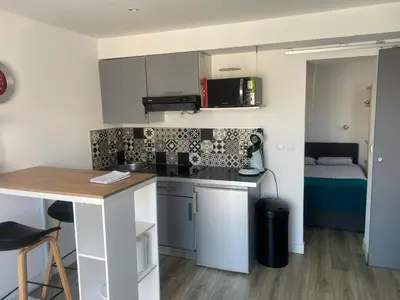 a small kitchen with a table and a bed at T2 Campo Meta in Furiani