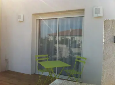 a green table and chairs in a room with a window at T2 Campo Meta in Furiani