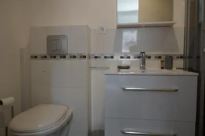 a white bathroom with a toilet and a sink at T2 Campo Meta in Furiani