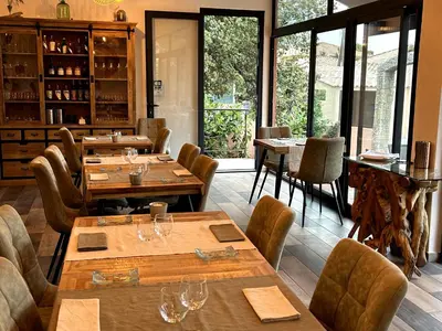 a restaurant with wooden tables and chairs and windows at Le Clos des Arbousiers in Linguizzetta