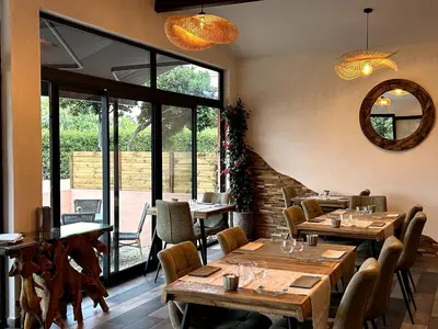 a restaurant with wooden tables and chairs and a mirror at Le Clos des Arbousiers in Linguizzetta