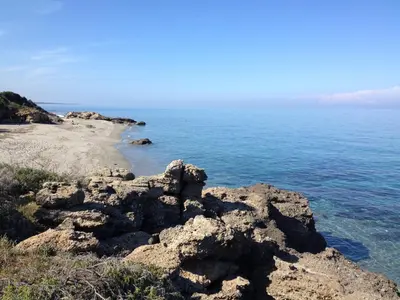 a view of the ocean from a rocky beach at Le Clos des Arbousiers in Linguizzetta