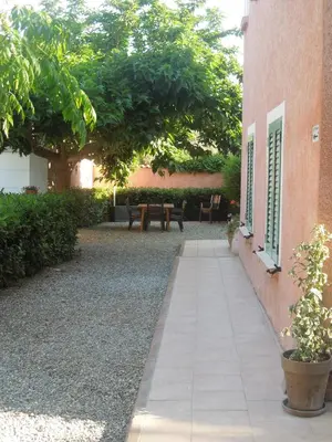 a walkway leading to a patio with a picnic table and trees at Le Clos des Arbousiers in Linguizzetta