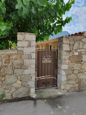 a gate to a building with a stone wall at Casa Petra in Corte