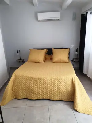 a bedroom with a bed with a yellow comforter and pillows at Casa Petra in Corte