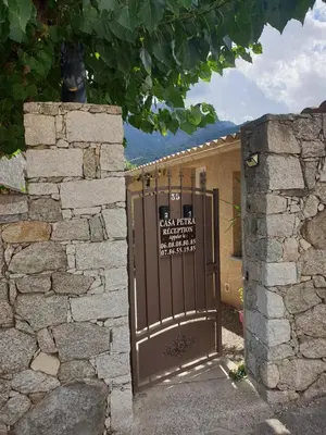 a gate to a building with a sign on it at Casa Petra in Corte