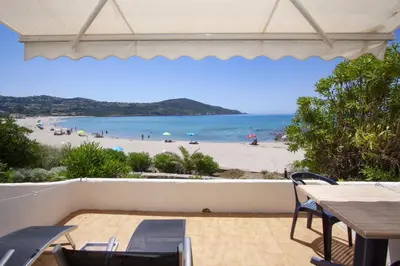a view of the beach from the balcony of a beach house at Hôtel et Résidence Ta Kladia - Omigna in Cargèse