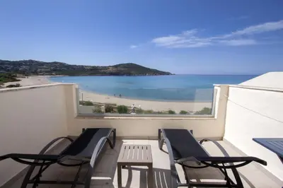 a balcony with chairs and a view of a beach at Hôtel et Résidence Ta Kladia - Omigna in Cargèse