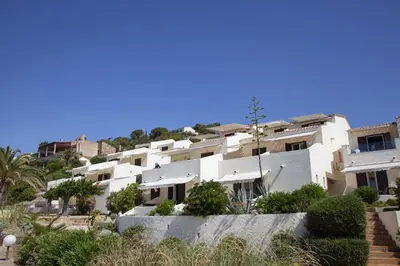 a white apartment building on the side of a hill at Hôtel et Résidence Ta Kladia - Omigna in Cargèse