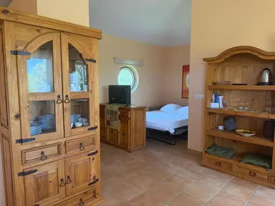 a room with a bedroom with a bed and a wooden cabinet at Apartment Pioppa for 4 in Porto-Vecchio